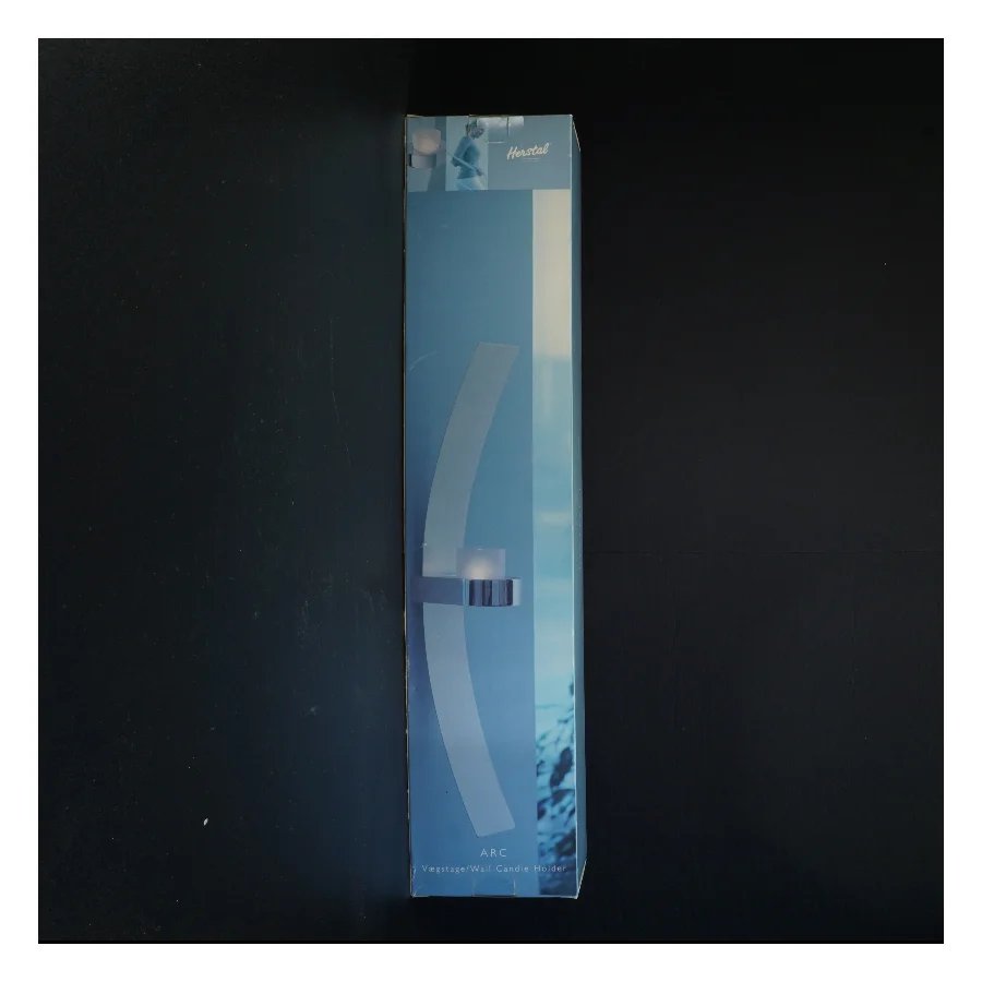 Væglysestage Arc fra Herstal i rustfrit stål (str. Kasse 58 x 12 og en halv cm)