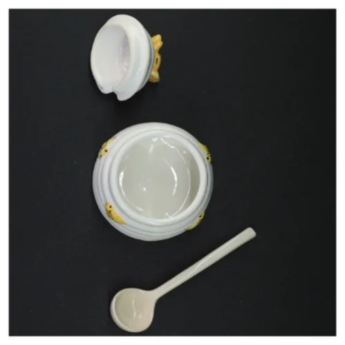 Honningkrukke med låg og ske (str. 10 komma 5 x 9 cm)