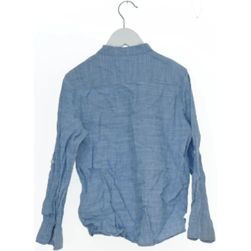 Lyseblå skjorte med lange ærmer fra H&M (str. 134)