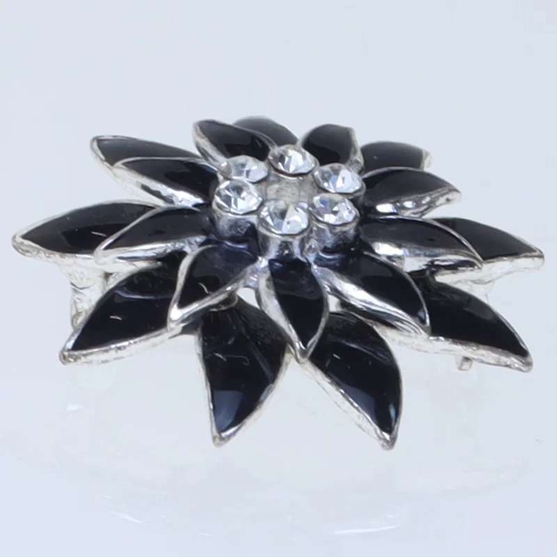 Blomstformet broche i sort (str. 3,5 cm)