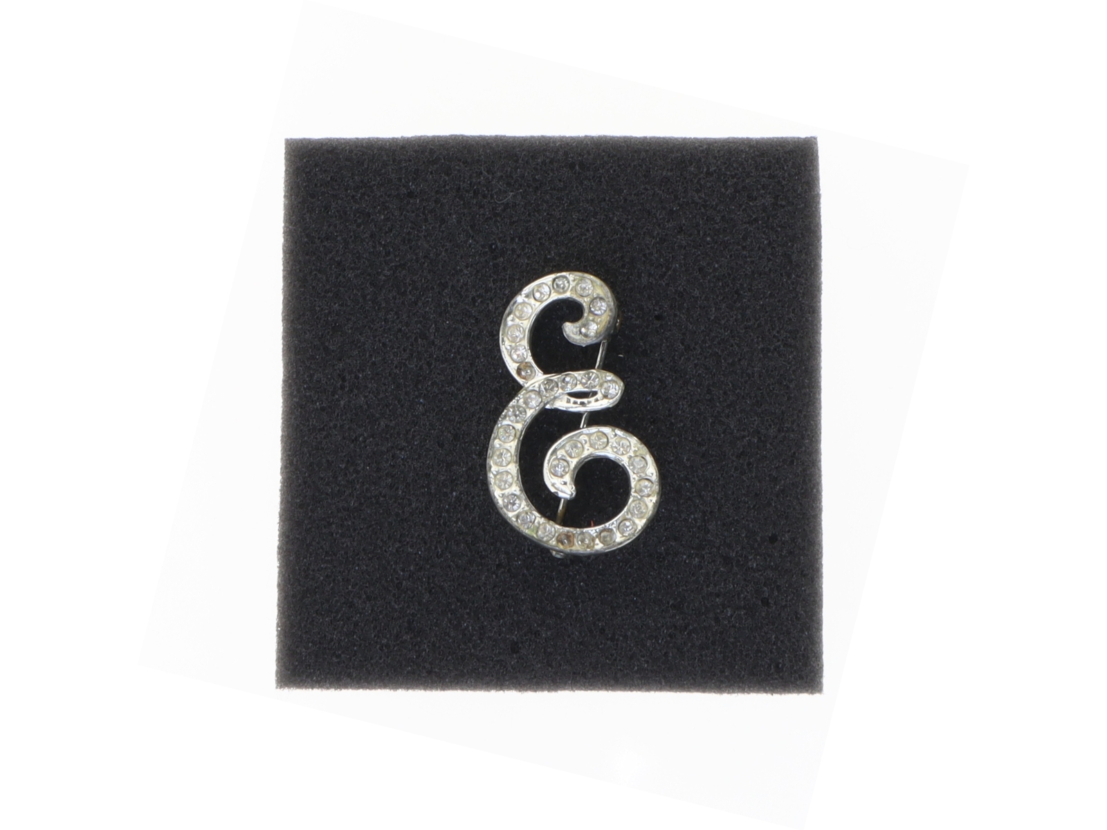 Sølvfarvet broche med sten (str. 3,5 x 2 cm)