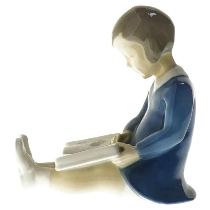 Porcelænsfigur af barn læsende fra B&G (str. 11x11,5 cm)